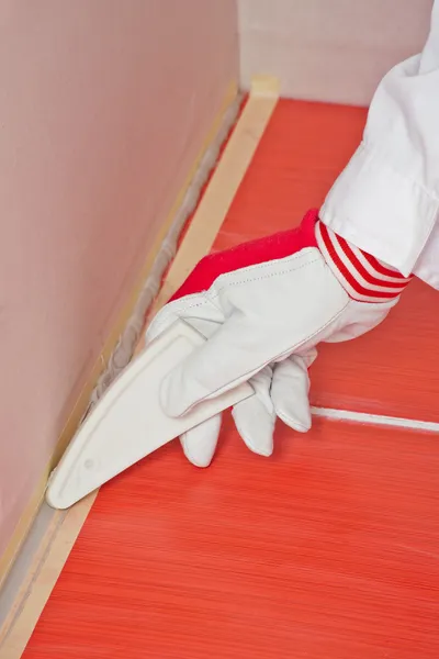 Worker with tool smooth silicone sealant on corner with tiles — Stock Photo, Image