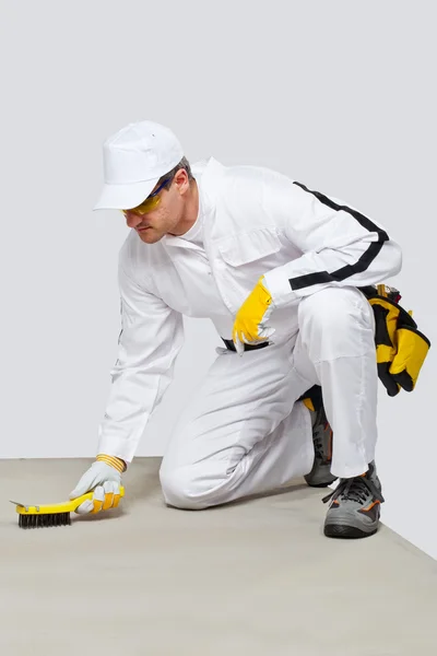 Worker with wire brush cleans the cement substrate — Stock Photo, Image