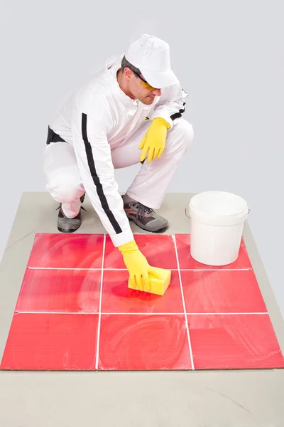 Arbeiter mit gelben Handschuhen und gelben Schwamm saubere Fliesen — Stockfoto