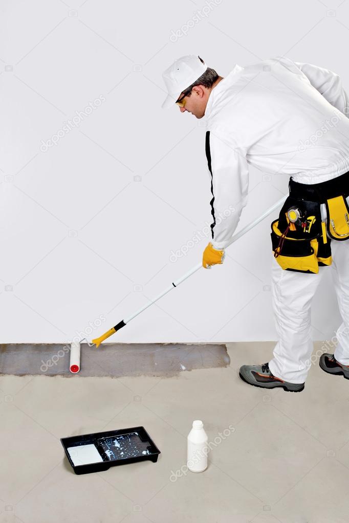 Worker paint with primer concrete floor for waterproofing