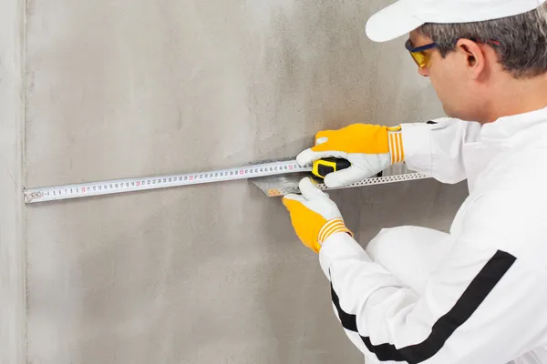 Worker measuring the level of a lath — Stock Photo, Image