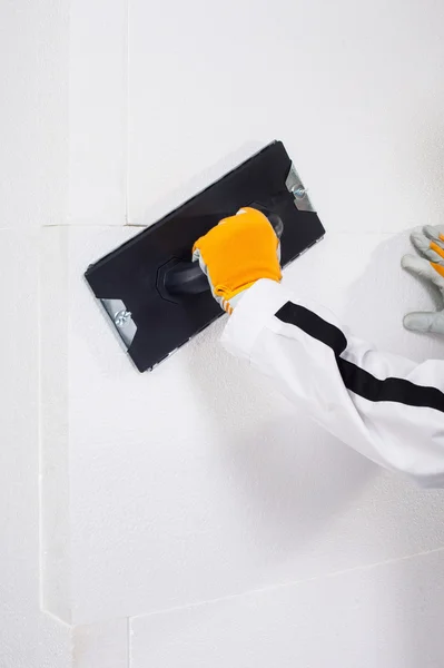 Worker rasping insulation panels — Stock Image Worker rasping insulation panels Stock Picture