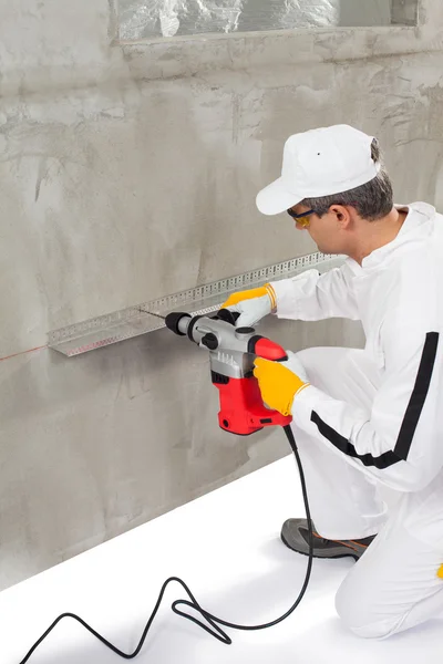 Trabajador haciendo un agujero a través de un listón — Foto de Stock