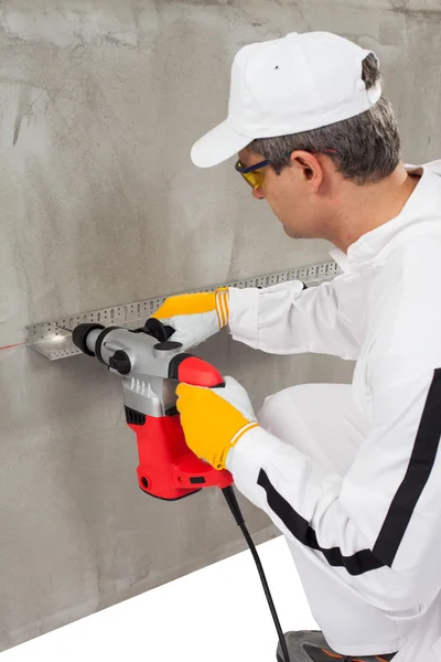 Worker making a hole through a lath — Stock Photo, Image