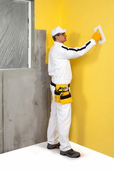 Trabajador esparciendo un yeso en una pared — Foto de Stock