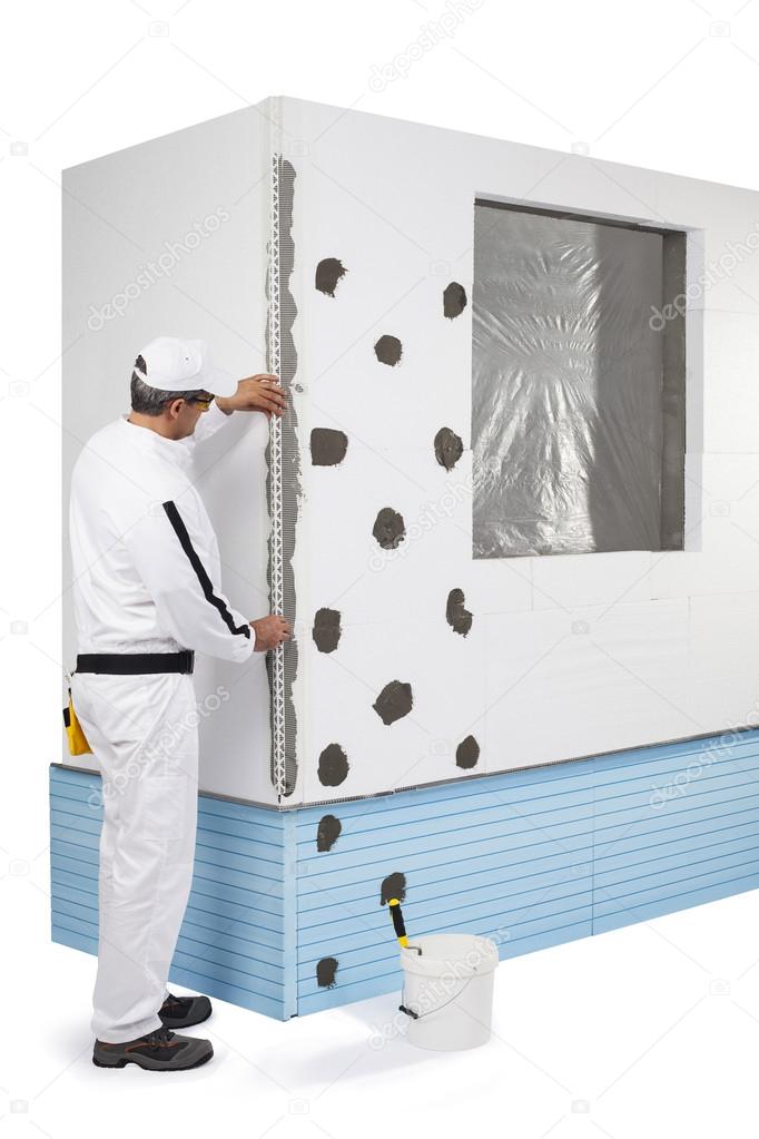 Worker coating a corner-lath with a putty