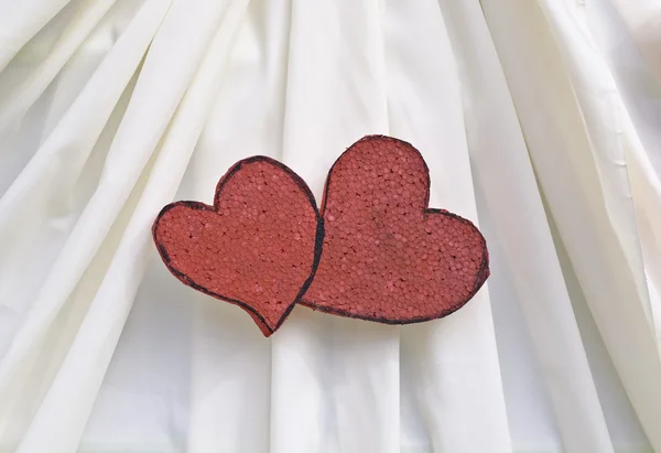 Red foam heart decorated on beige cloth — Stock Photo, Image