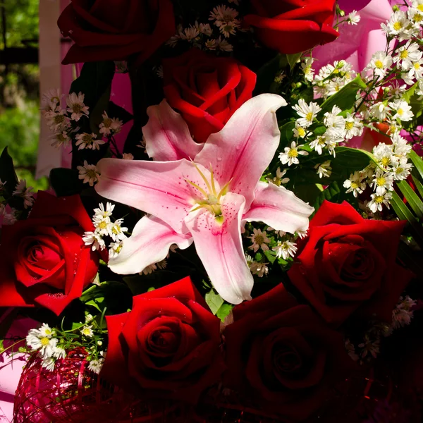 Bouquet of pink lily with red roses in shadow — Stock Photo, Image