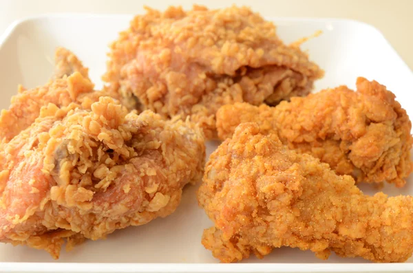 Pollo fritto marrone dorato nel piatto bianco — Foto Stock
