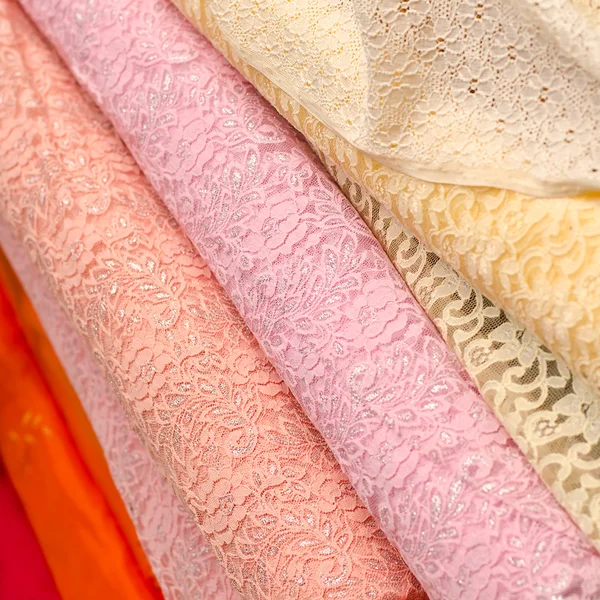 Магазин тканин зі стосами з різнокольорового мереживного текстилю — стокове фото