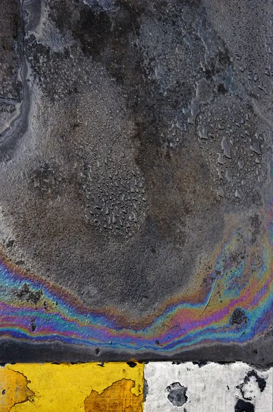 Разлив нефти на фоне асфальтированной дороги или текстуре — стоковое фото