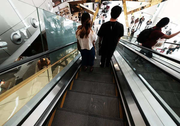 Metrodaki yürüyen merdivendeki insanlar.