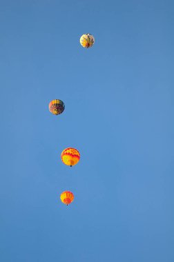 2021 Albuquerque NM Balon Şenliği 'nde sabah melteminde renkli bir sıcak hava balonu süzülür..