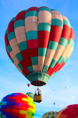 2021 Albuquerque NM Balon Şenliği 'nde sabah melteminde renkli bir sıcak hava balonu süzülür..