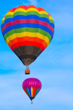 2021 Albuquerque NM Balon Şenliği 'nde sabah melteminde renkli bir sıcak hava balonu süzülür..