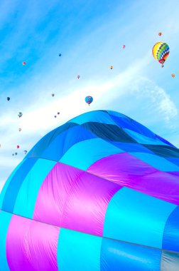 2021 Albuquerque NM Balon Şenliği 'nde sabah melteminde renkli bir sıcak hava balonu süzülür..