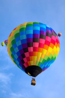 2021 Albuquerque NM Balon Şenliği 'nde sabah melteminde renkli bir sıcak hava balonu süzülür..