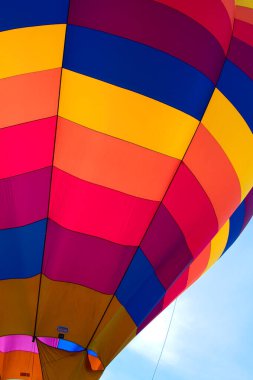 2021 Albuquerque NM Balon Şenliği 'nde sabah melteminde renkli bir sıcak hava balonu süzülür..