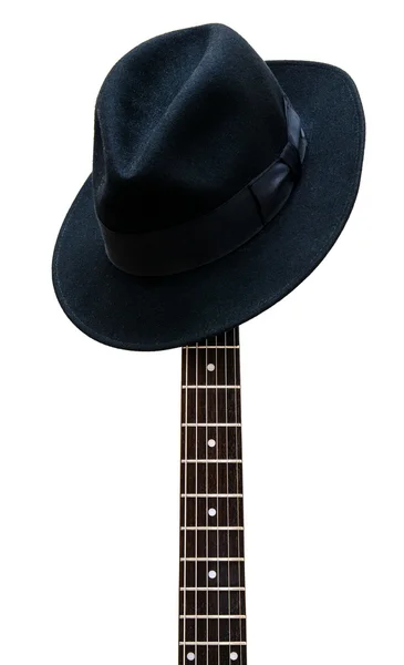 Vintage hoed rusten op een gitaar fretboard geïsoleerd achtergrond Stockafbeelding