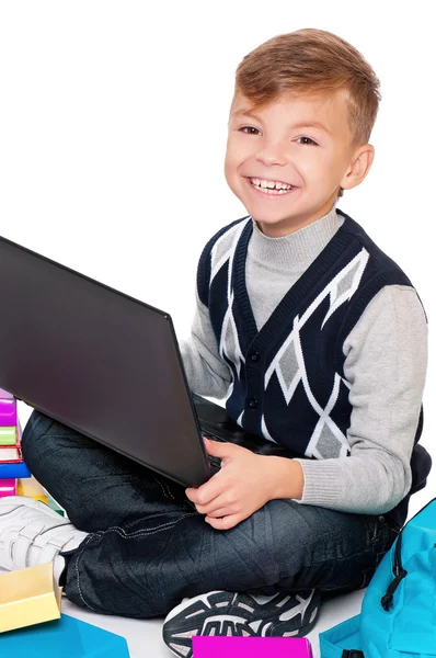 Pojke med bärbar dator och böcker — Stockfoto