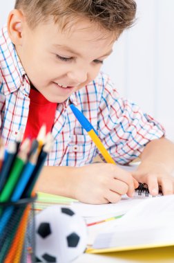 Çocuk ödevini yapıyor.