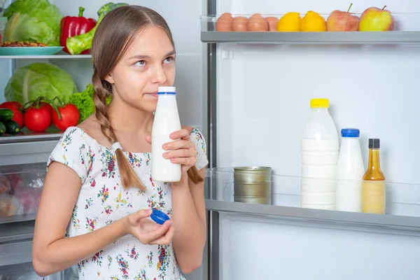 Menina com comida perto da geladeira — Fotografia de Stock