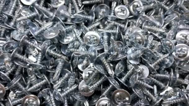 Muchos tornillos autorroscantes de fondo. Fabricación de fijación de metal. Hardware para reparación o fijación — Vídeos de Stock