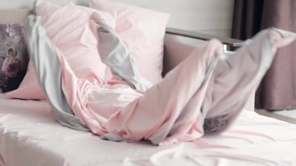 Crazy kids home play. Child having fun, playing ghost, climbed inside the duvet cover and liying in bed in the morning — Stock Video