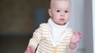 Küçük bebek mutfakta dans ediyor ve çocukların şarkılarını dinliyor. Mutlu bir çocukluk