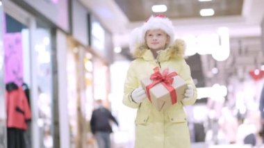 Noel 'de Noel Baba şapkalı küçük kız alışveriş merkezinde geleneksel markette yürüyor. Xmas Çocukluk Tatili Konseptini Sunar.