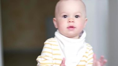 Küçük bebek mutfakta dans ediyor ve çocukların şarkılarını dinliyor. Mutlu bir çocukluk