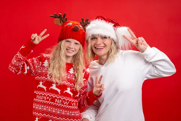 クリスマス休暇肖像画幸せな家族の2でサンタ帽子の母親と娘立っていると笑顔で赤いスタジオの背景 — ストック写真