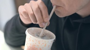 Erkek öğrenci McDonalds fast food restoranında Coca Cola içiyor. Sağlıksız beslenme, abur cubur, abur cubur. 26aug2021 St Petersburg Rusya