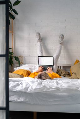 Distance learning online education and work.Happy woman girl working office work remotely from home on bed. Using computer laptop