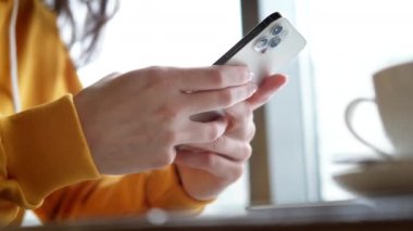 iPhone 12 akıllı telefon kullanan, parmak basan, sosyal medya interneti okuyan, metin yazan ya da internetten alışveriş yapan bir kız. Cep telefonu evde ya da 20.12.21 St. Petersburg Rusya 'da.