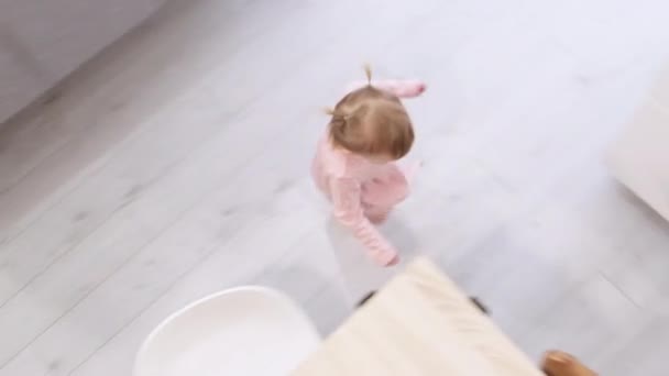 Klein schattig 2 jaar oud meisje met plezier rondrennen keukentafel in plaats van eten, Problemen met het voeden van een kind. Bovenaanzicht — Stockvideo