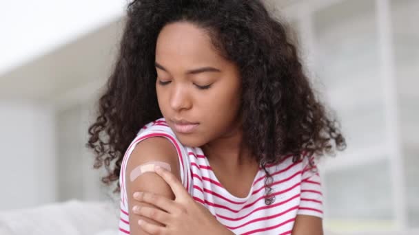 Femme afro-américaine vaccinée montrant le bras avec un patch de plâtre médical sur l'épaule, femelle noire après avoir reçu une dose de vaccin contre la covide. Immunisation des soins de santé, vaccination contre le coronavirus. — Video