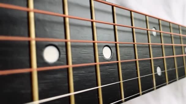 Zoom in shot of black frets fretboard acoustic guitar string — Stock Video