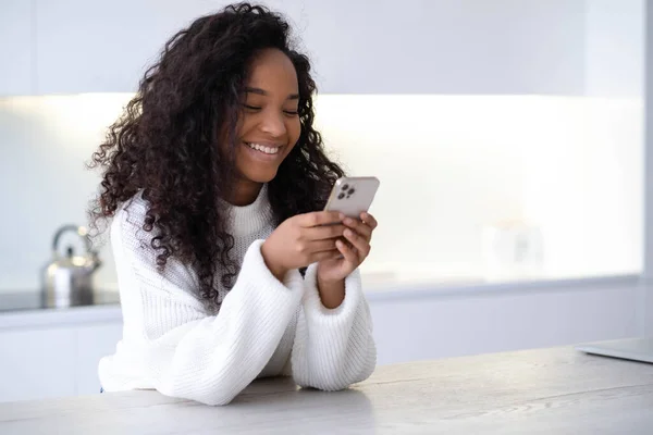 Afrikai-amerikai lány iPhone 12 okostelefon nyomja ujját, olvassa a közösségi média internet, gépelés szöveg vagy vásárlás online Mobiltelefon két fekete kezekben 13.12.21 Szentpétervár Oroszország Stock Kép