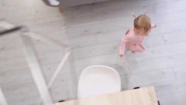 Klein schattig 2 jaar oud meisje met plezier rondrennen keukentafel in plaats van eten, Problemen met het voeden van een kind. Bovenaanzicht. 26.5.21 Sint-Petersburg Rusland — Stockvideo