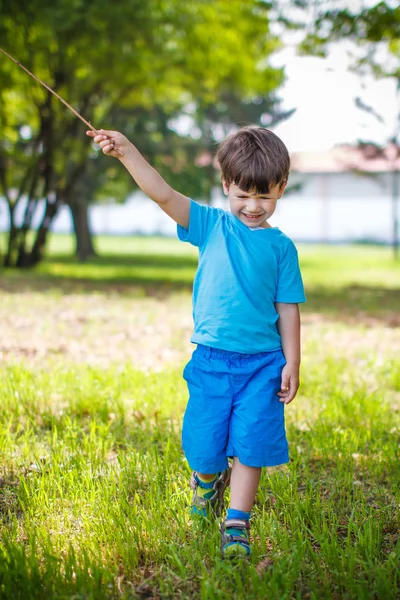 Jongen met tanden glimlach en lange stok — Stockfoto