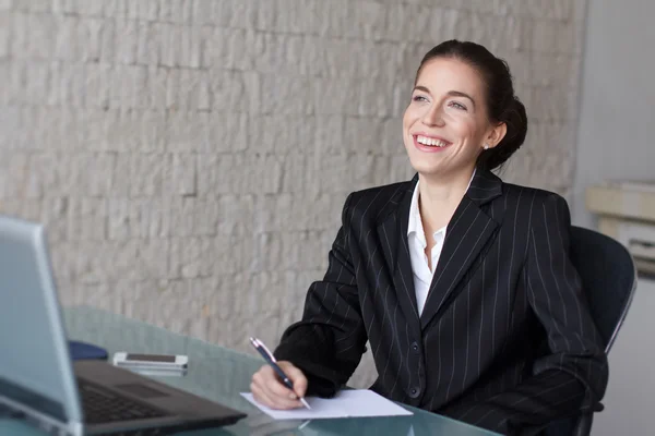 Vacker affärskvinna skriver i office — Stockfoto
