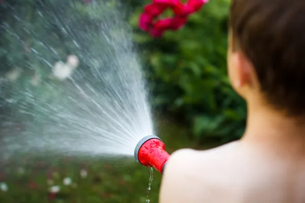 Kleine jongen irrigeren in tuin — Stockfoto