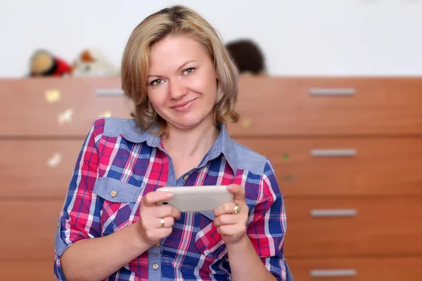 Mujer feliz en casa con smartphone —  Fotos de Stock