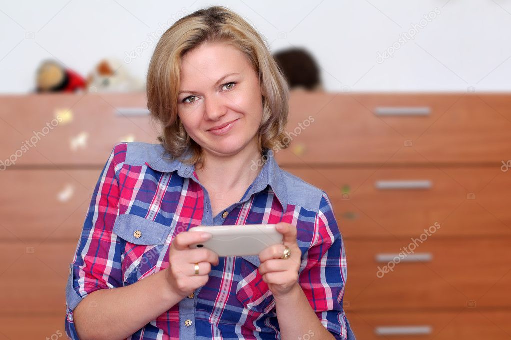 Happy woman at home with smartphone