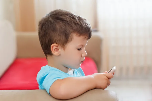 Kleiner Junge spielt auf Smartphone — Stockfoto