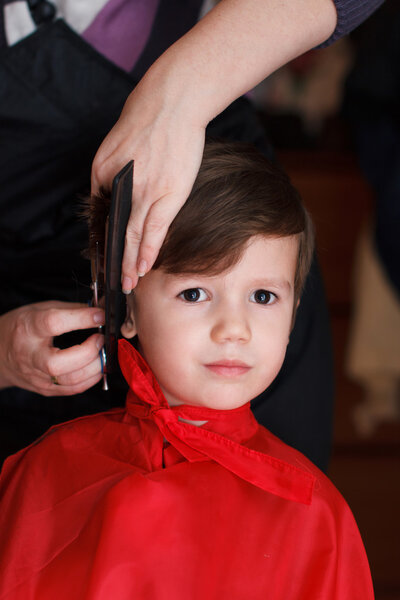 Young child with smile at the hairdresser having a haircut