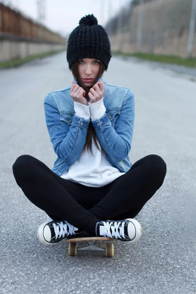 Молодая модная брюнетка-скейтбордистка — стоковое фото