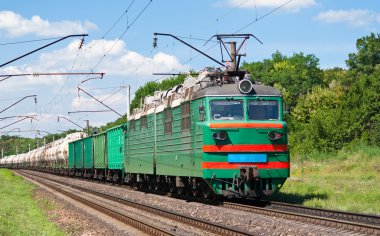 Elektrikli lokomotif bir yük treni bastırıyor