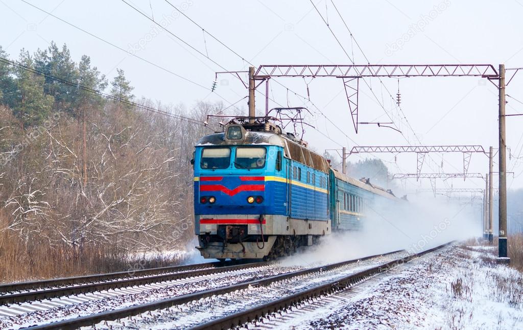 Passenger train rapidly moving along the snow track